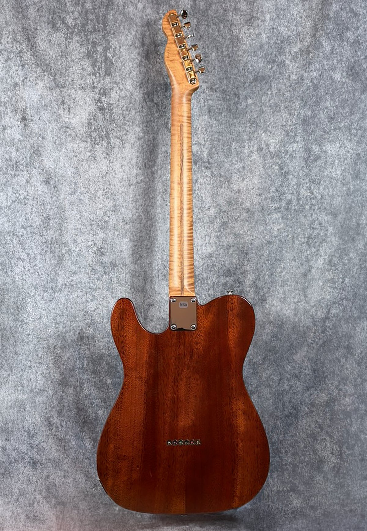 The back of a LsL "Thin Bone" guitar with a roasted, flamed maple neck and a red mahogany body.